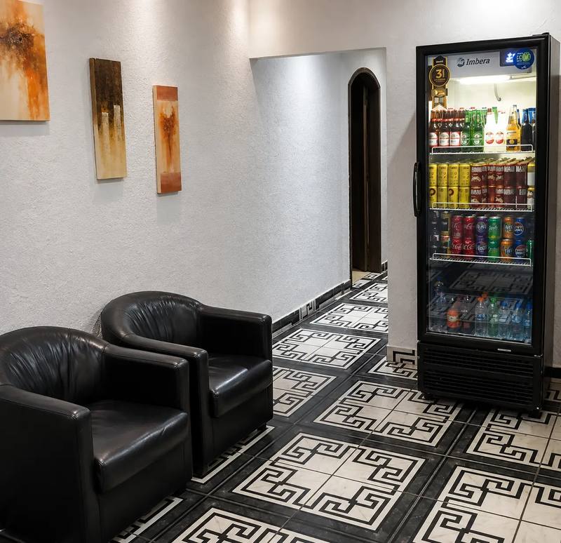 Recepção com poltronas de couro e um refrigerador de bebidas
