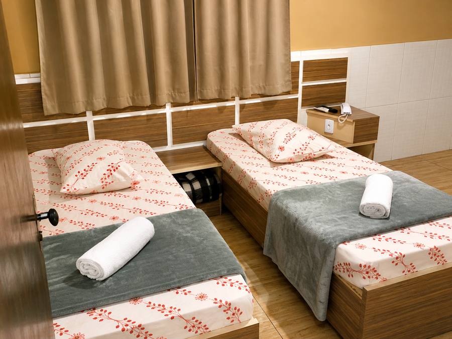 Quarto duplo com duas camas de solteiro e toalhas limpas